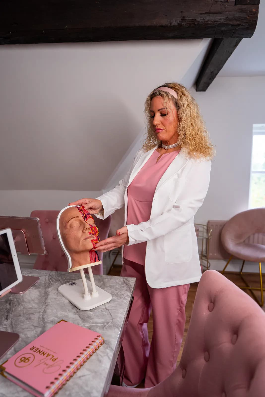 An academy tutor explaining facial anatomy using a teaching model inside Cherry Tree House.