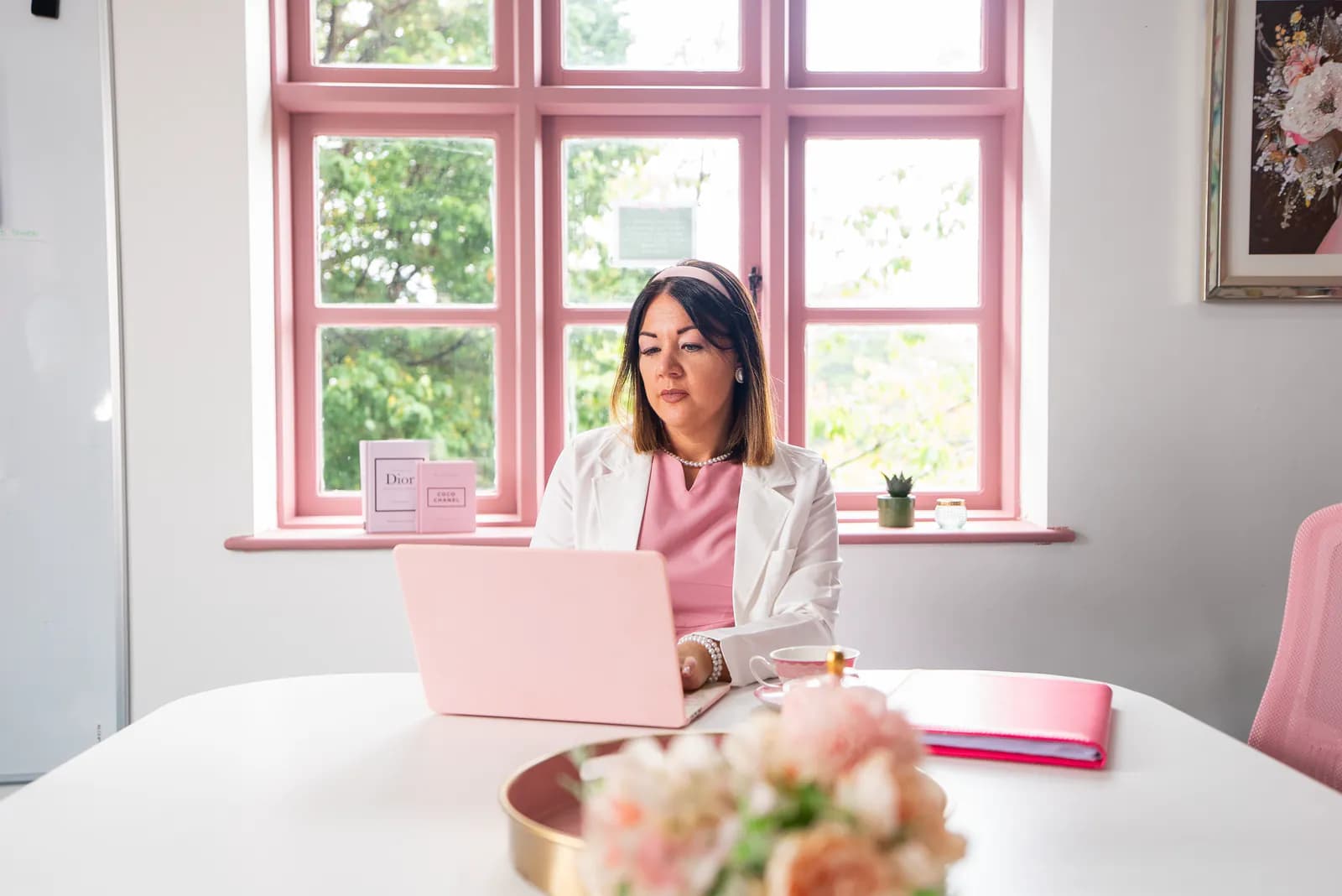 A member of the academy team working at a pink laptop in the Cherry Tree House office.