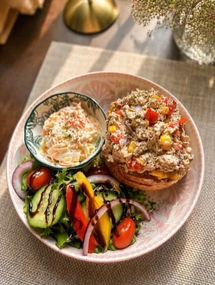 A loaded farmhouse jacket potato served with a dressed side salad