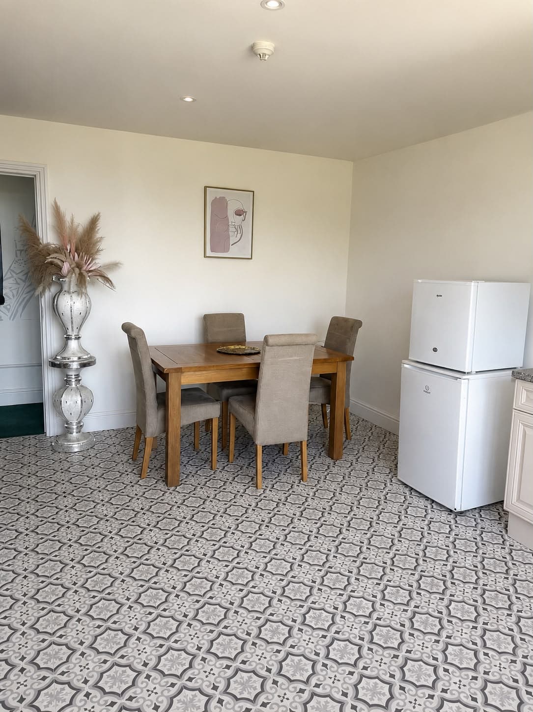 A dining table and chairs beside a fridge and kitchen counter at the Cherry Tree Cafe